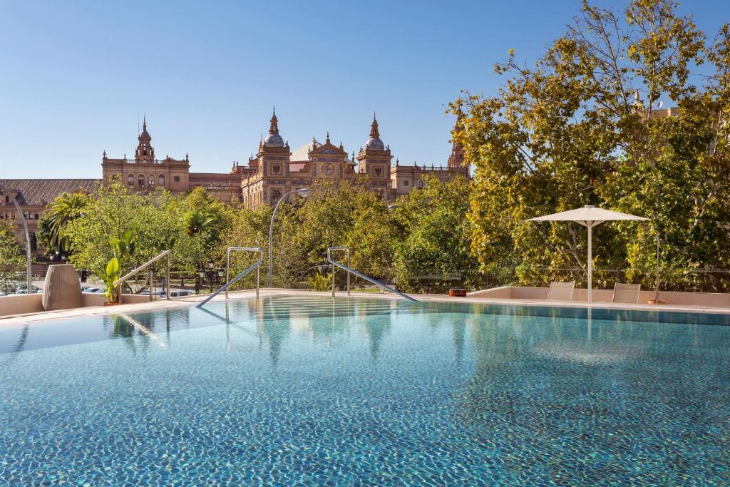 a large swimming pool in front of a large building at Meliá Sevilla in Seville