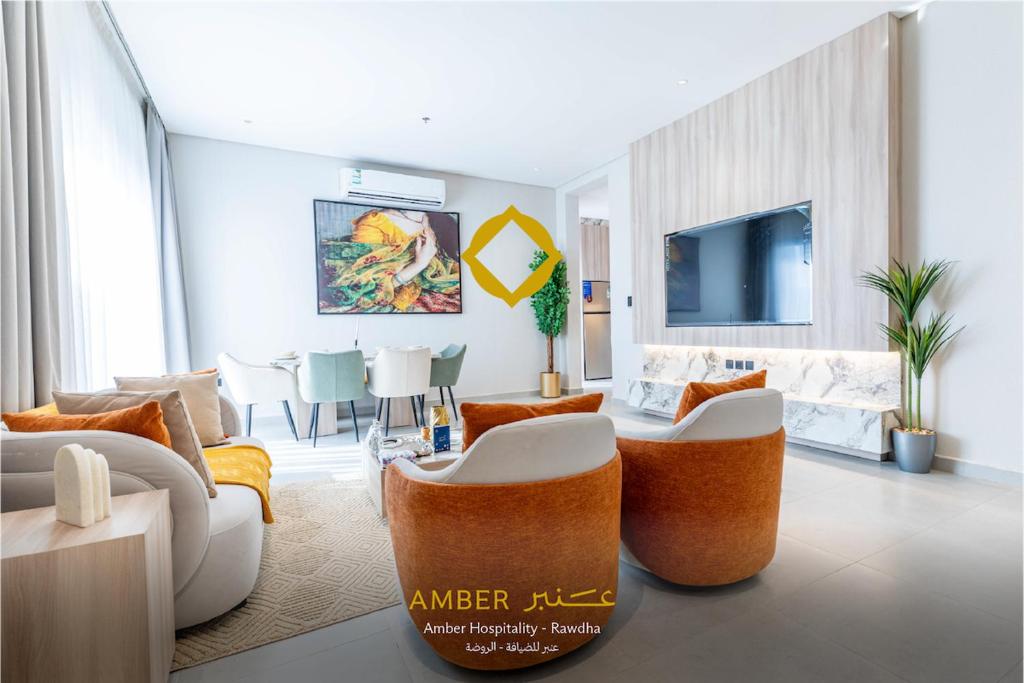 a living room with orange and white furniture at Amber Hospitality - Arrawdha in Riyadh