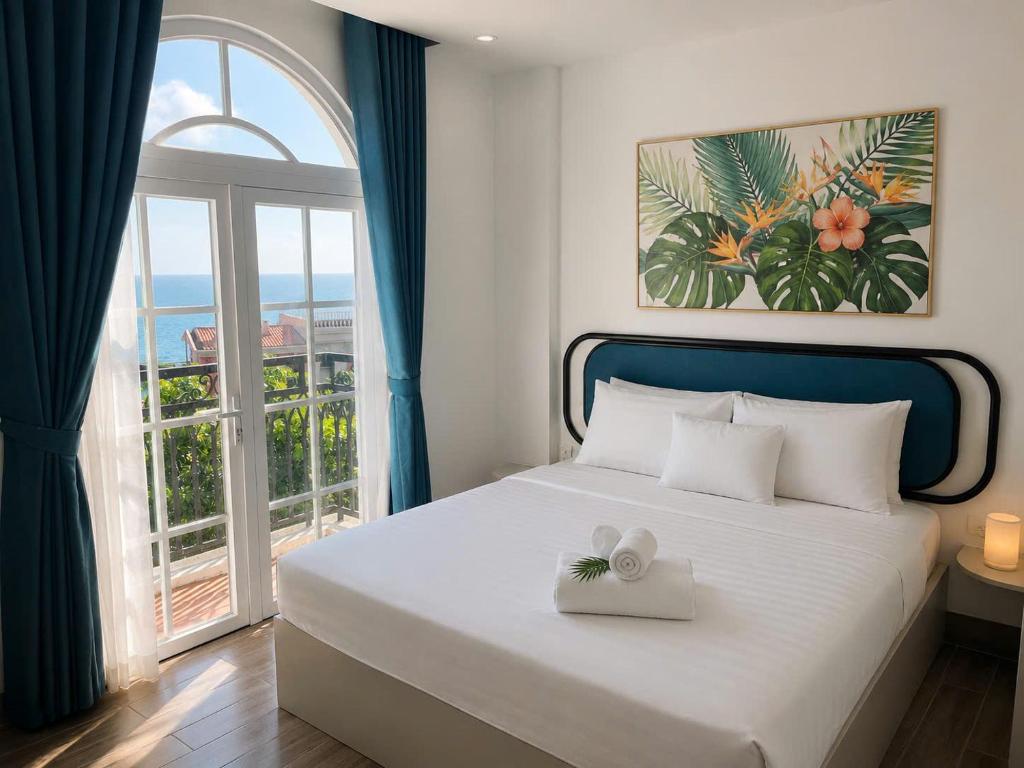 a bedroom with a bed and a large window at Blue Hotel Sunset Town Phu Quoc in Phú Quốc