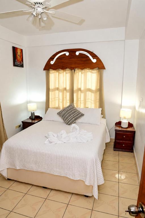 a bedroom with a white bed with a canopy at EV's Place in San Ignacio