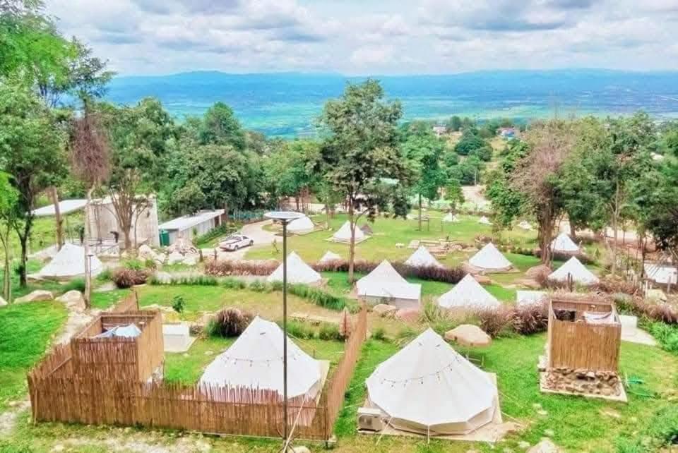 a group of tents in a field with trees at โอโซนสตอรี่ in Ban Fai Mon
