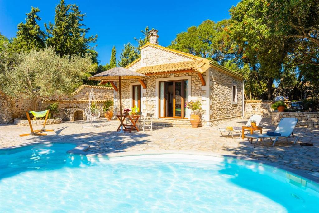 a small stone house with a pool in front of it at Villa Nionios in Vlachopoulátika
