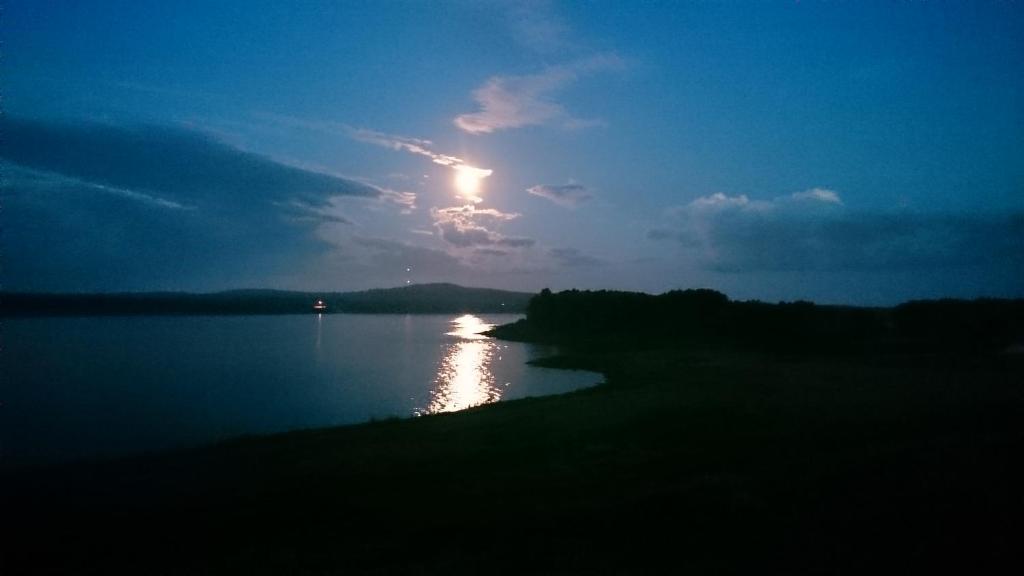 a sun setting over a body of water at Nivagården in Korpikylä