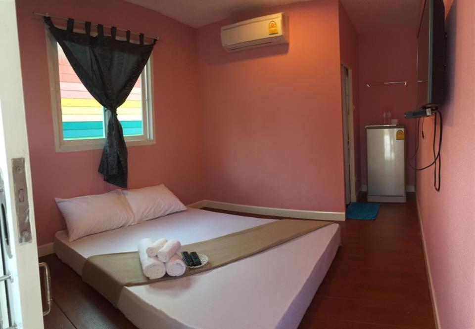 1 dormitorio con 1 cama blanca grande y ventana en Se'sun Amphawa, en Amphawa