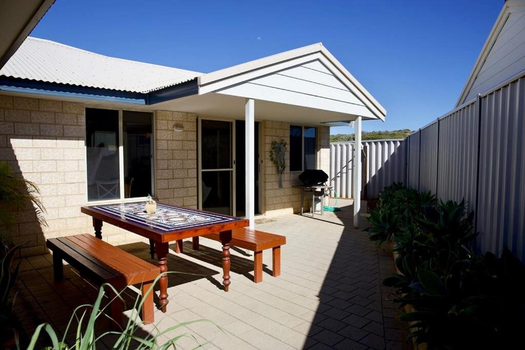 a patio with a table and benches on a house at Villa LaNoah in Kalbarri