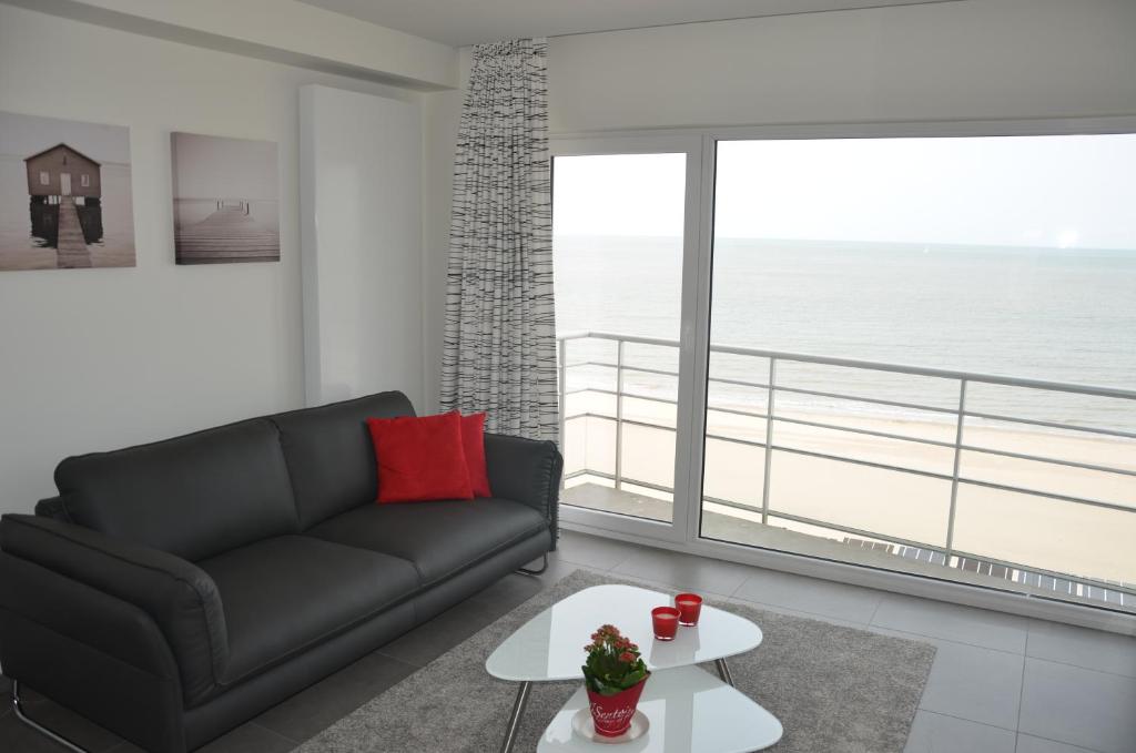 - un salon avec un canapé noir et une grande fenêtre dans l'établissement 4B @ Longchamp, à Ostende