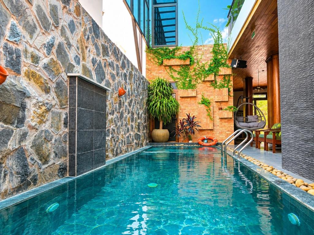 a swimming pool in a house with a stone wall at Daisy's Villa TamCoc in Ninh Binh