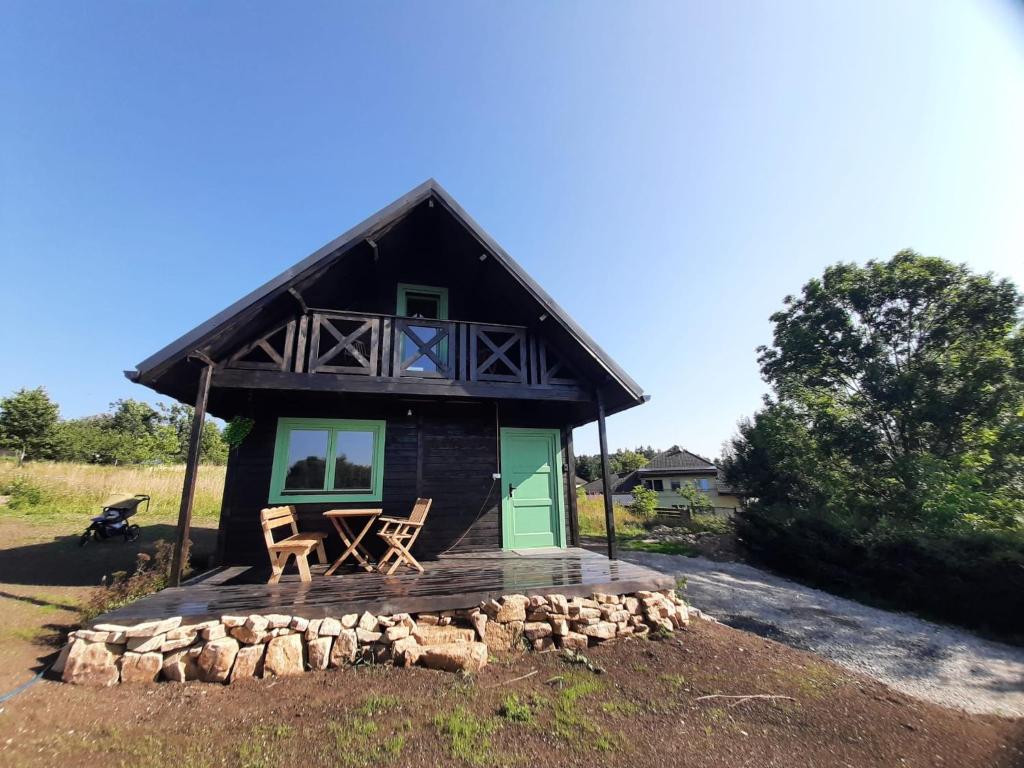 a small cabin with two chairs on a wooden deck at Chata Tisá in Tisá