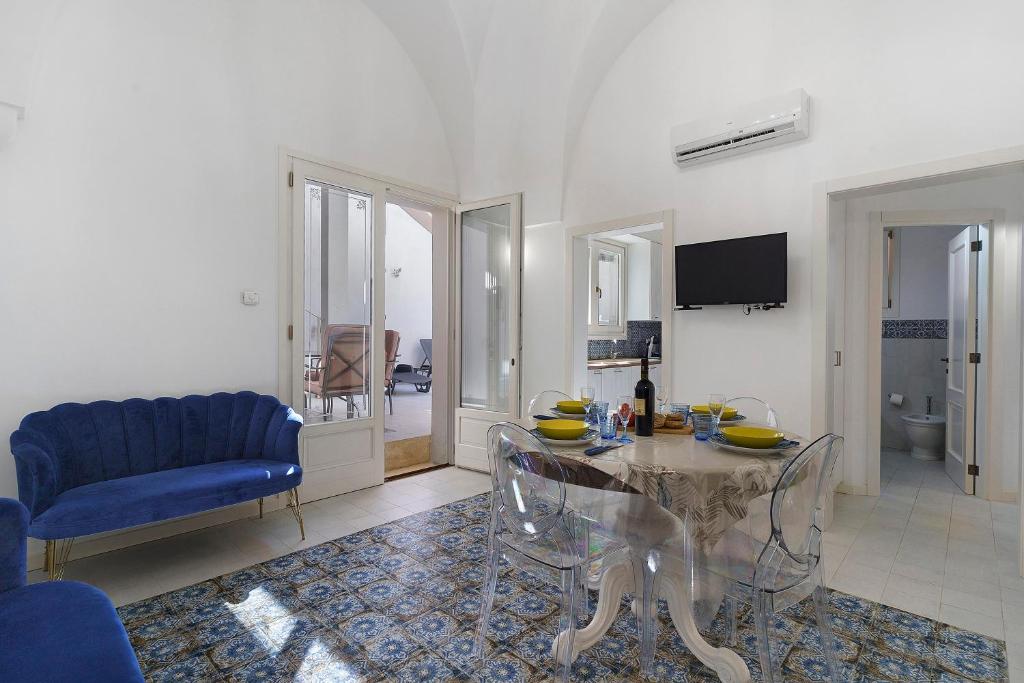 a living room with a glass table and a blue couch at Dimora Collina 2 in Sannicola