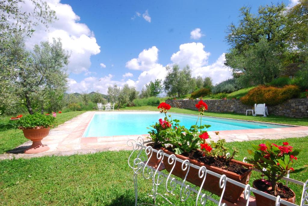 ein Pool mit Blumen im Hof in der Unterkunft Casina in Gaiole in Chianti