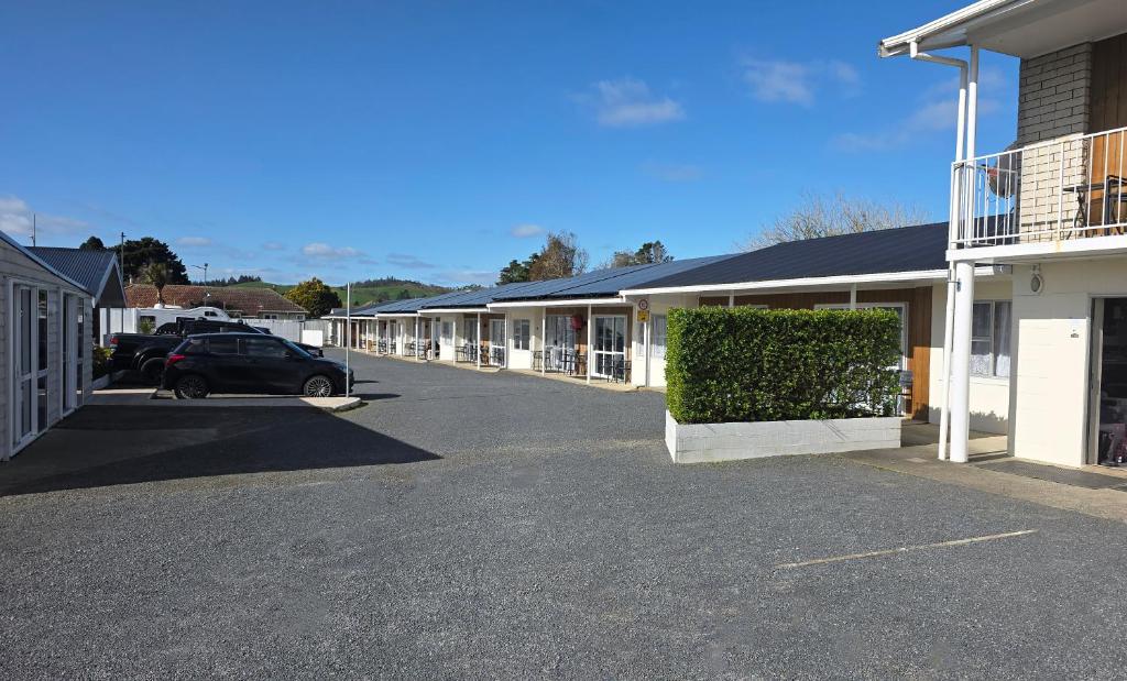 a car parked in front of a row of buildings at Twin Coast Adventures Motel & Cycle Hire in Kaikohe
