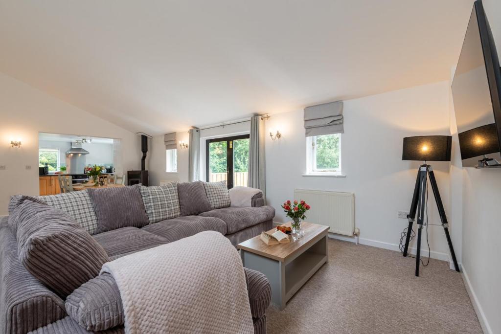 a living room with a couch and a table at Warner - Treworgie Barton Cottages in Bude