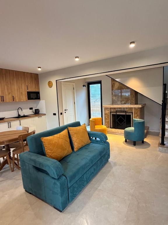 a living room with a blue couch and a kitchen at Chanko's Cottages in Tsemi