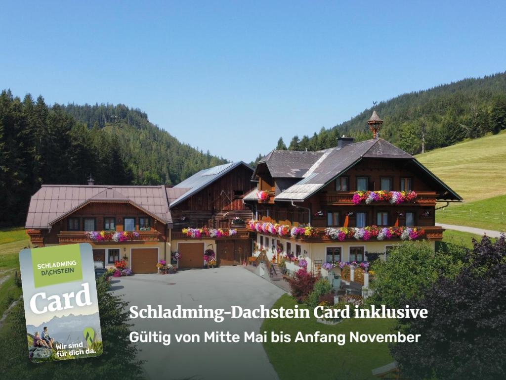 a large building with a sign in front of it at Pension-Greimelbacherhof in Ramsau am Dachstein