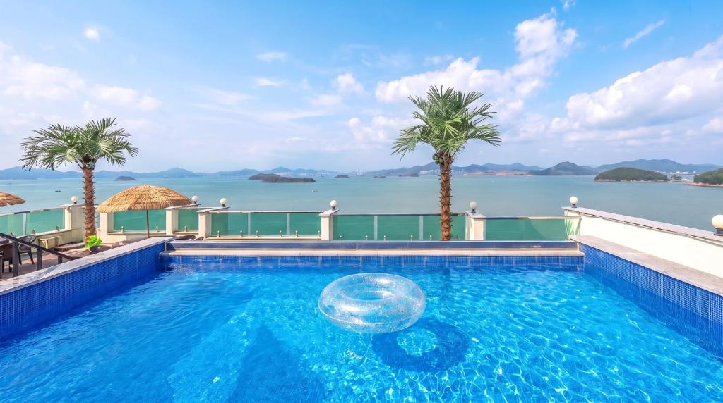 a swimming pool with a view of the water at Yeosu Hemiswi SPA Pension in Yeosu