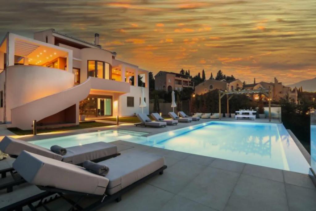 a villa with a swimming pool with lounge chairs at Casa Grande Private Luxury Villa in Alykes Potamou