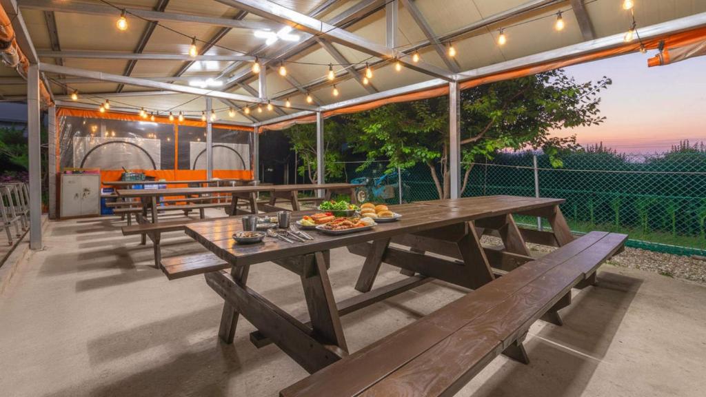 an outdoor dining area with wooden tables and benches at Samcheok Greenhyang Pension in Samcheok