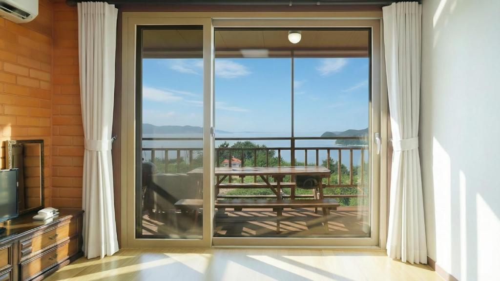 a sliding glass door with a view of a table at Yeosu Hwangto Pension in Yeosu