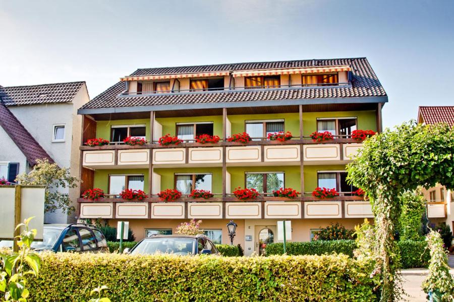 a yellow building with red flowers on it at Gästehaus Merk Merk Gbr in Immenstaad am Bodensee