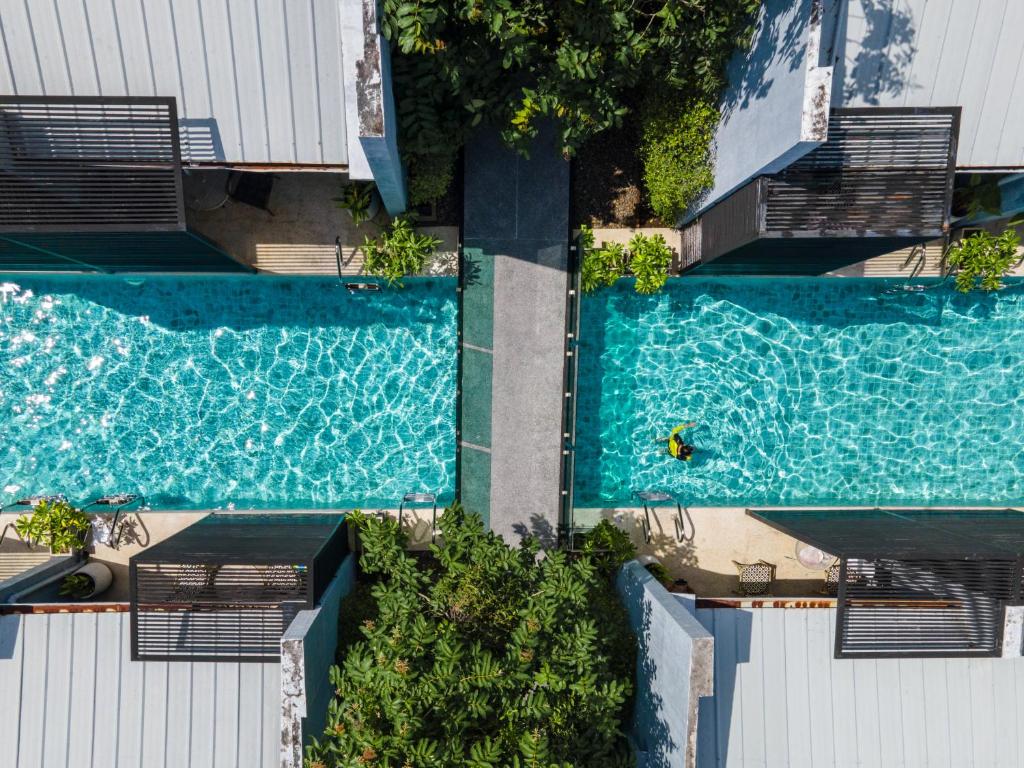 Draufsicht auf zwei Schwimmbecken neben einem Gebäude in der Unterkunft Xen Pool Access Phuket in Chalong 