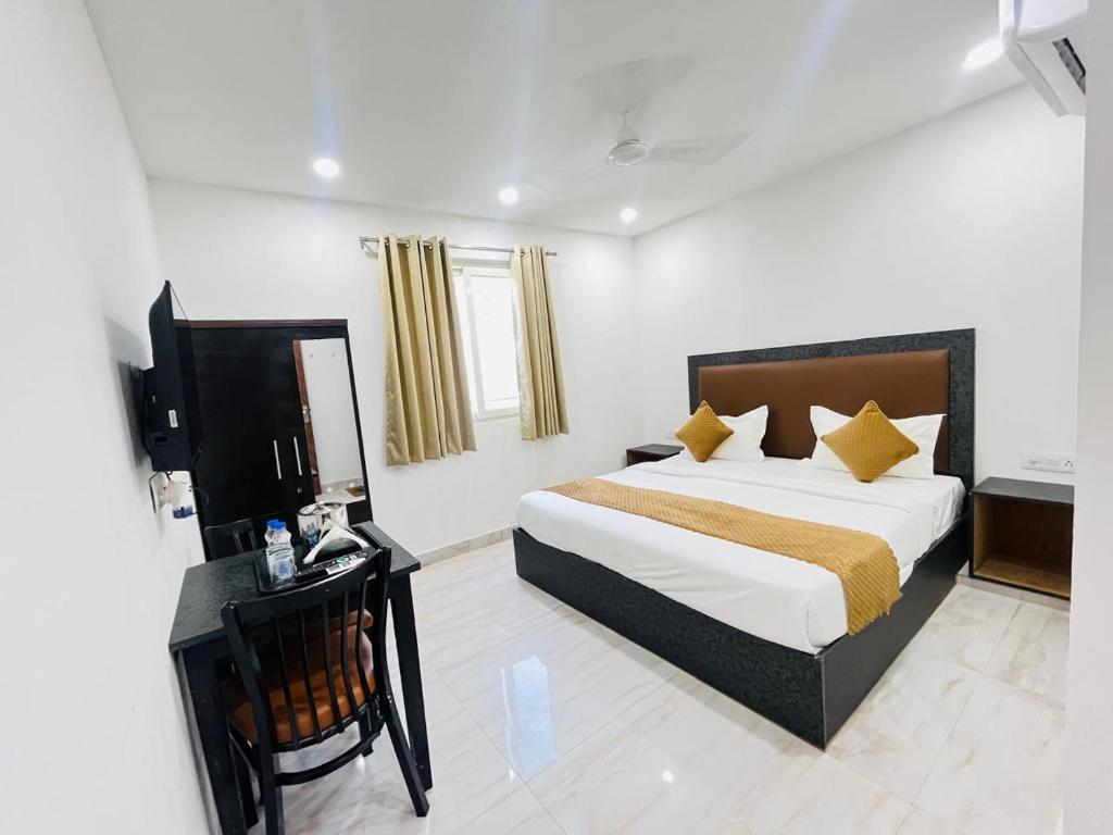pokój hotelowy z łóżkiem, biurkiem i łóżkiem w obiekcie Hotel Vasundhara Villa - Greater Kailash w Nowym Delhi