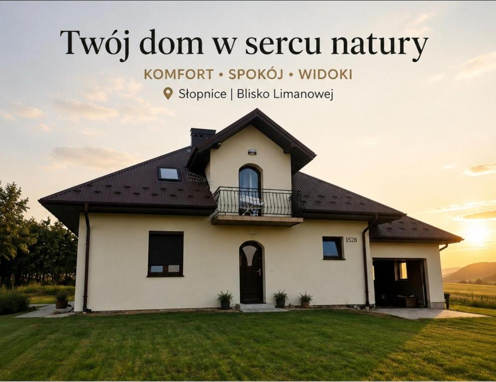 a white house with a balcony on top of a yard at Oko na Mogielice in Słopnice