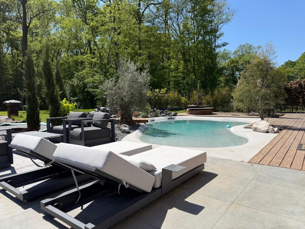 a swimming pool with chaise lounges and a swimming pool at Villa golf merignies in Mérignies