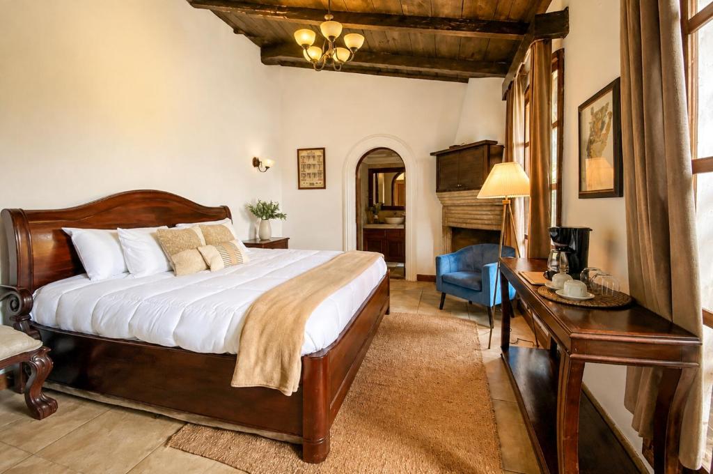 a bedroom with a bed and a table and a desk at Nifu nifa in Antigua Guatemala