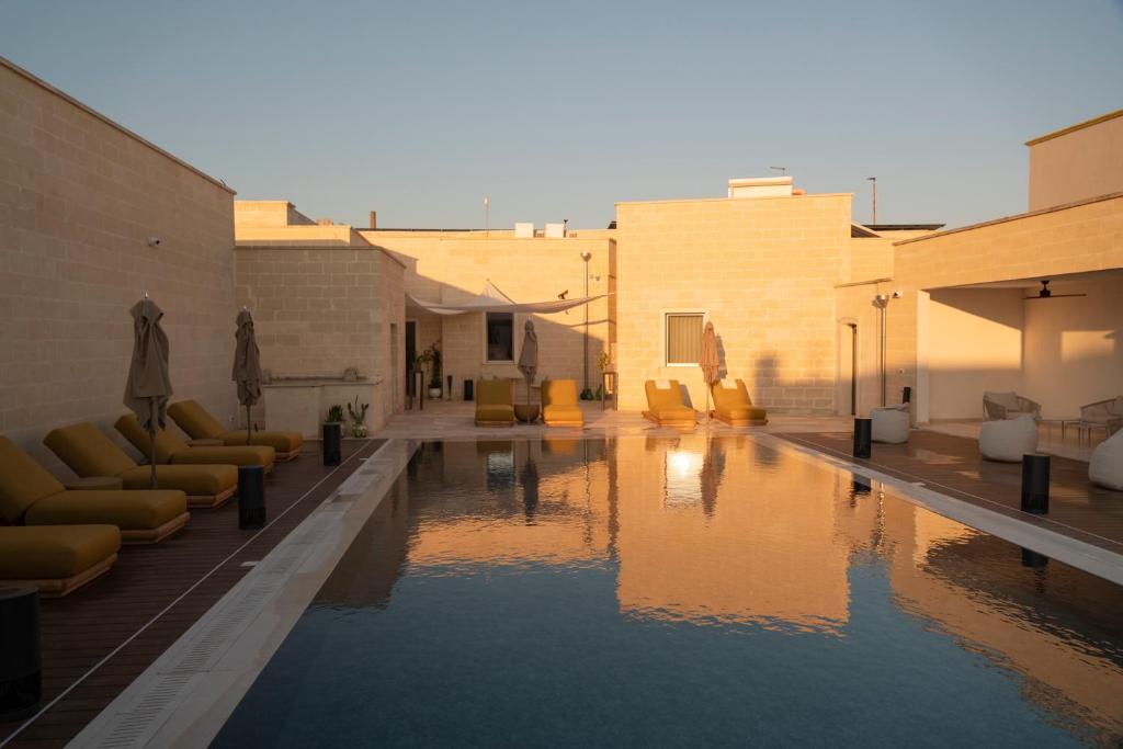 a large swimming pool with chairs and chairs in a building at Dimora Mennuti in Monteparano