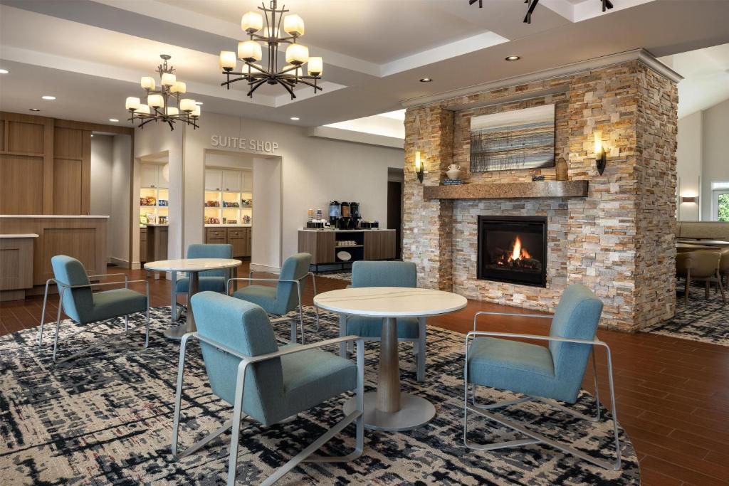a lobby with tables and chairs and a fireplace at Homewood Suites New Brighton in Roseville