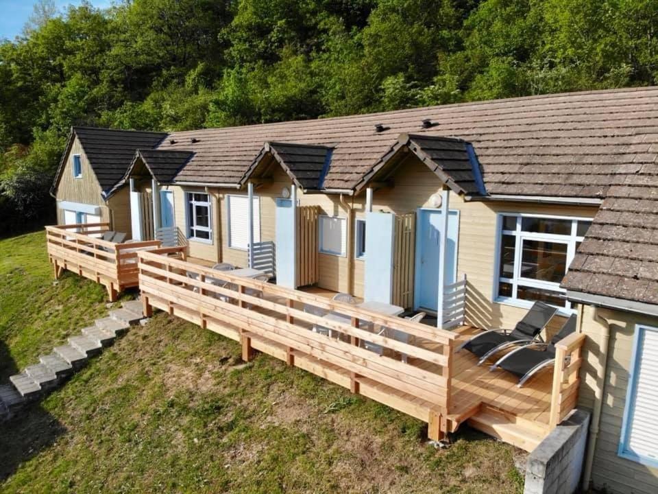 a row of cottages with a large wooden deck at La Tuile Aux Loups in Corps