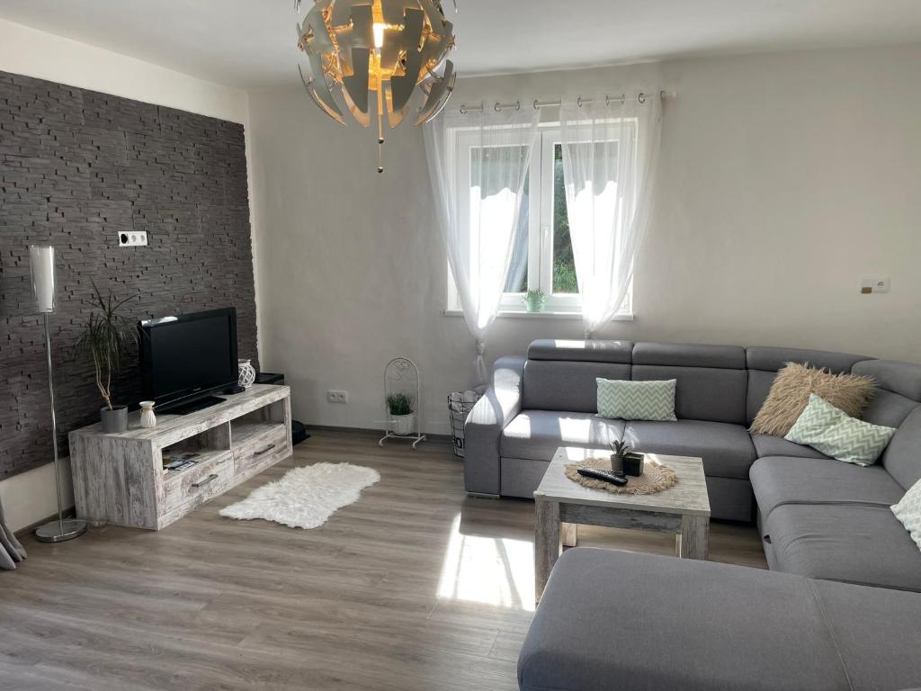 a living room with a couch and a tv at Apartmán u Fryšávky in Fryšava
