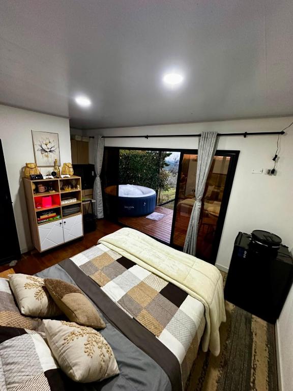 a bedroom with two beds and a sliding glass door at Tres Raices Cabañas in Gómez Plata