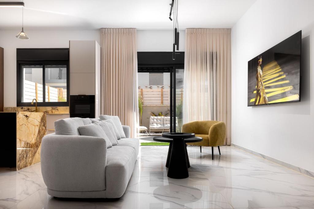a living room with a white couch and chairs at Katalina Luxury Apartment Eilat in Eilat