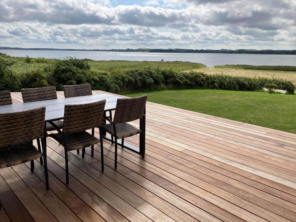 a wooden deck with a table and chairs on it at 14234-Grevinge-Strandmosen-11 in Grevinge