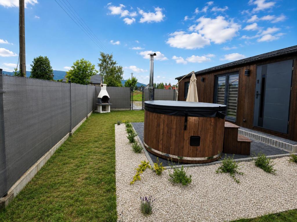 a backyard with a hot tub and a building at Górskie Zakątek in Kalna