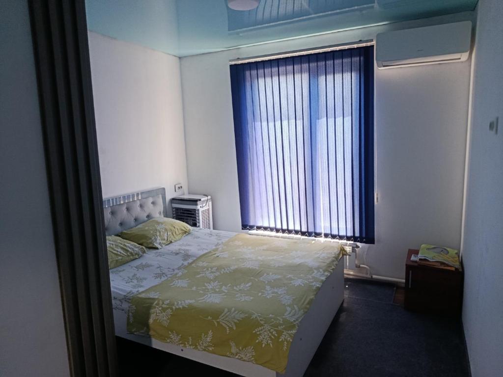 a bedroom with a bed and a large window at Asian Guest House in Bishkek