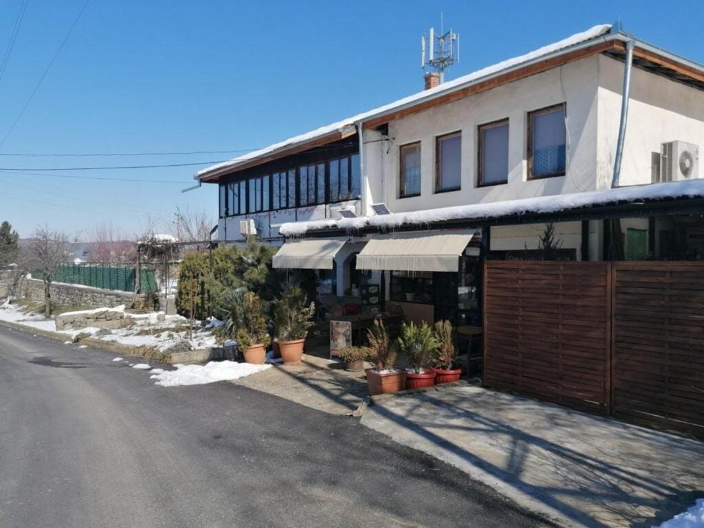 a building with potted plants on the side of a street at Shumata Guest House in Natsovtsi