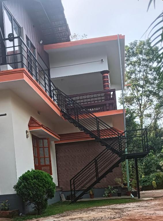 a house with a spiral staircase on the side of it at Mount Star Home Stay in Kakkabe