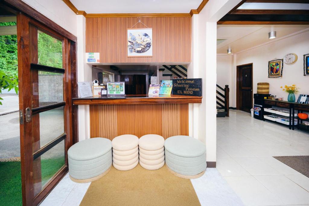 a restaurant with a counter and stools in a room at Silverise Guest House in El Nido