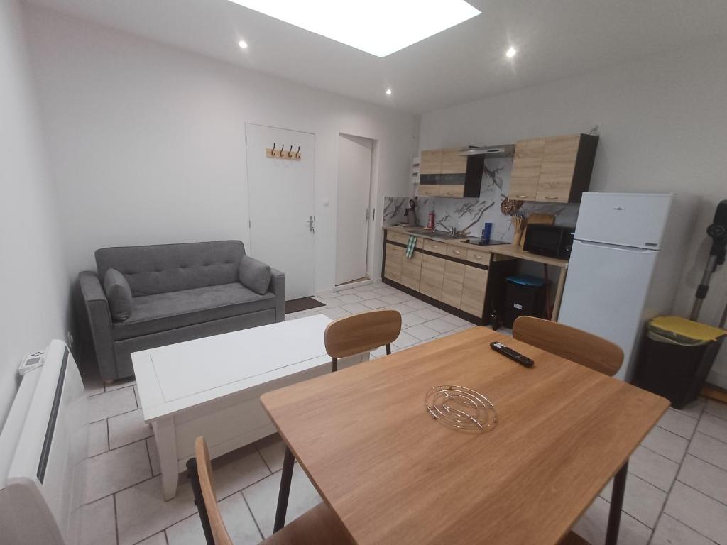a kitchen and living room with a table and a couch at Studio-Cosy 17-18-19 Centre Bourbourg in Bourbourg