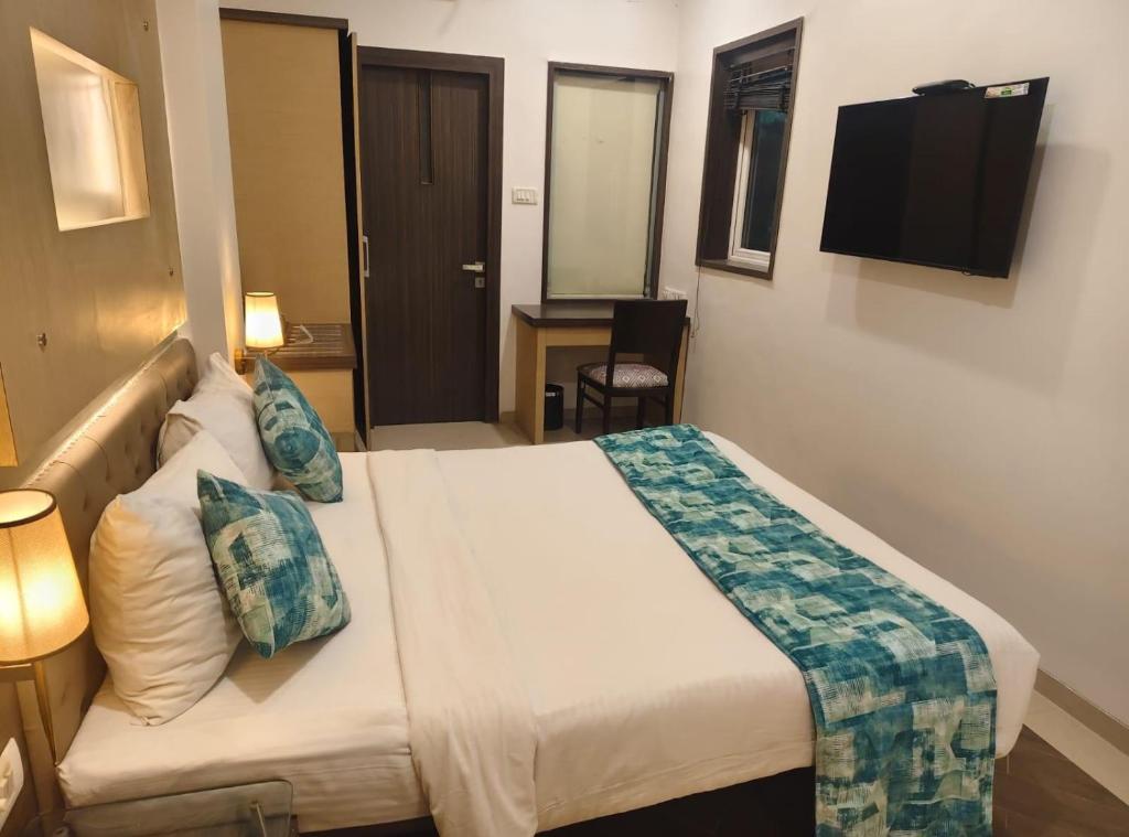 a hotel room with a bed and a desk at Hotel Mumbai House Thane in Thane
