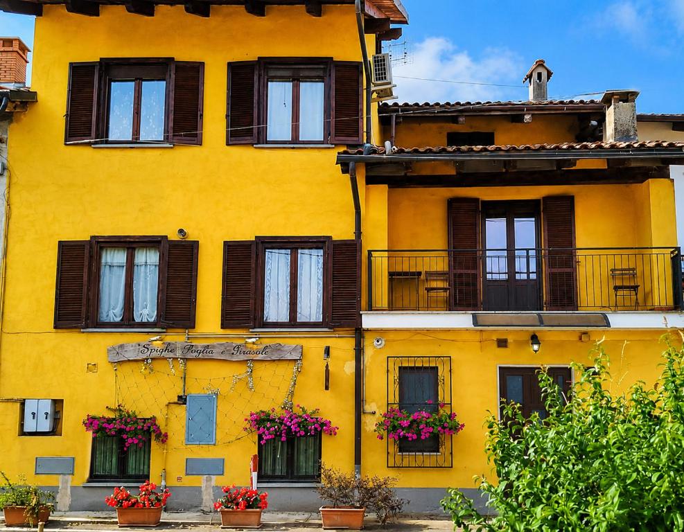 a yellow building with windows and balconies at Spighe Paglia e Girasole in Candia Canavese