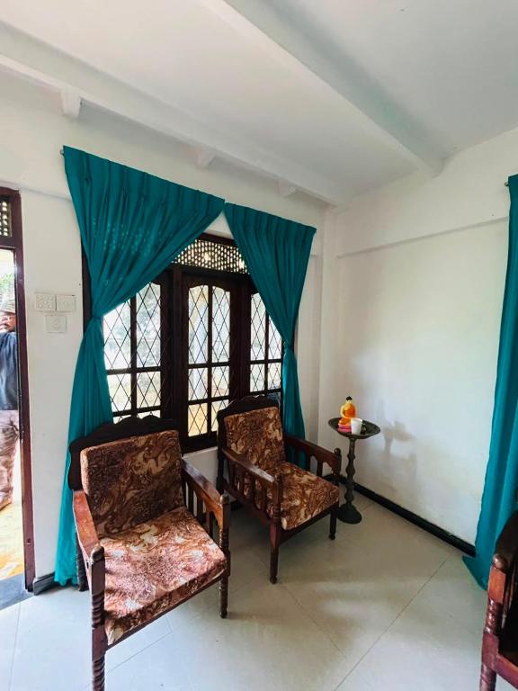 a living room with two chairs and a window at OLA Villa in Mawella