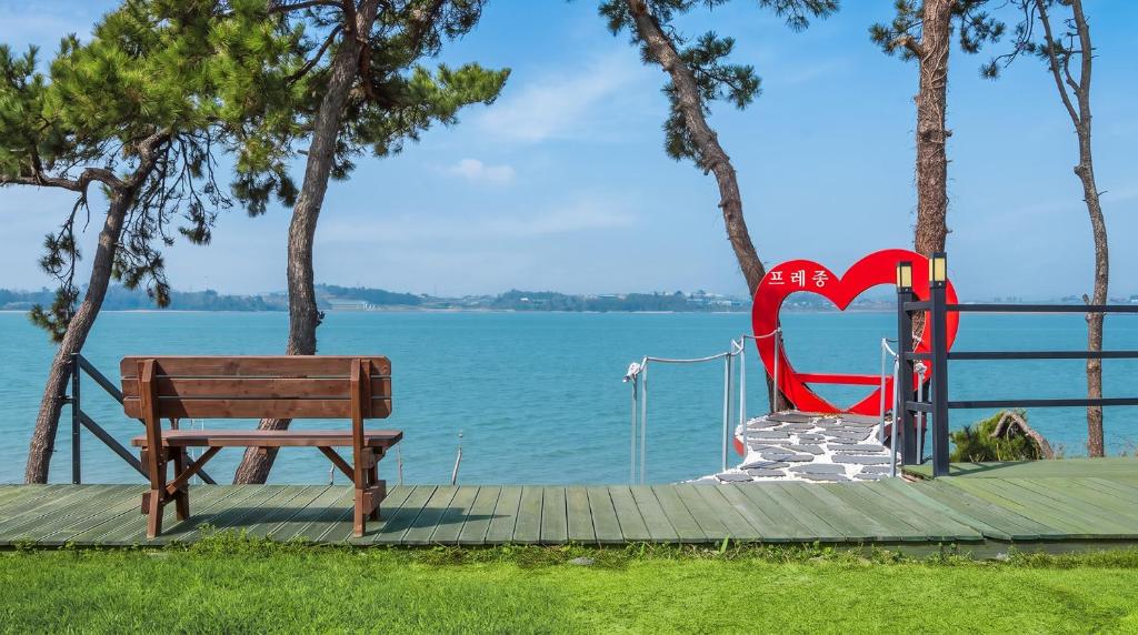 a bench sitting on a dock next to the water at Mu-an Prejong Dokchae Pension in Muan