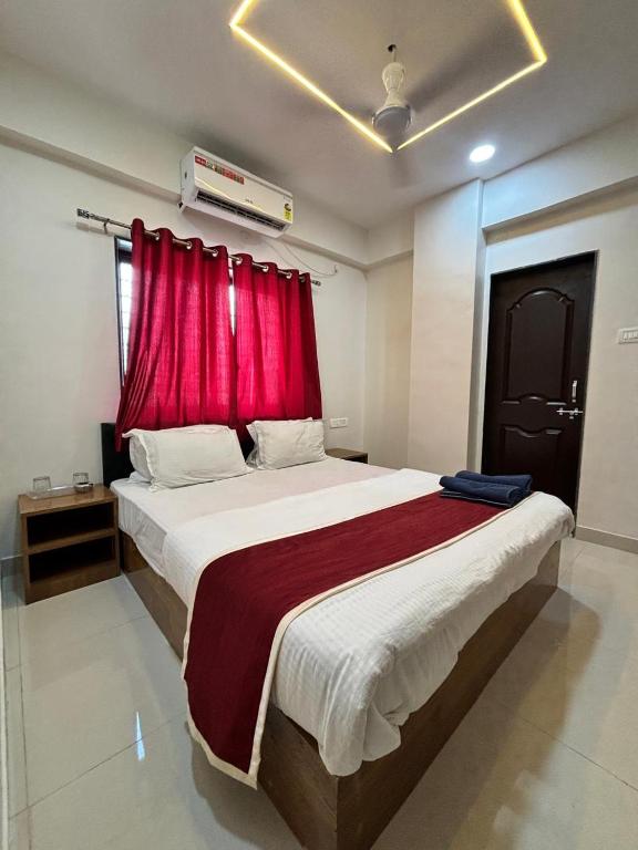 a bedroom with a large bed with a red curtain at Rajratna lodge in Lohogaon