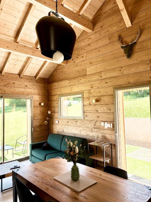 a living room with a wooden ceiling and a table at Le Chalet du Soleil Levant in Longevilles-Mont-dʼOr