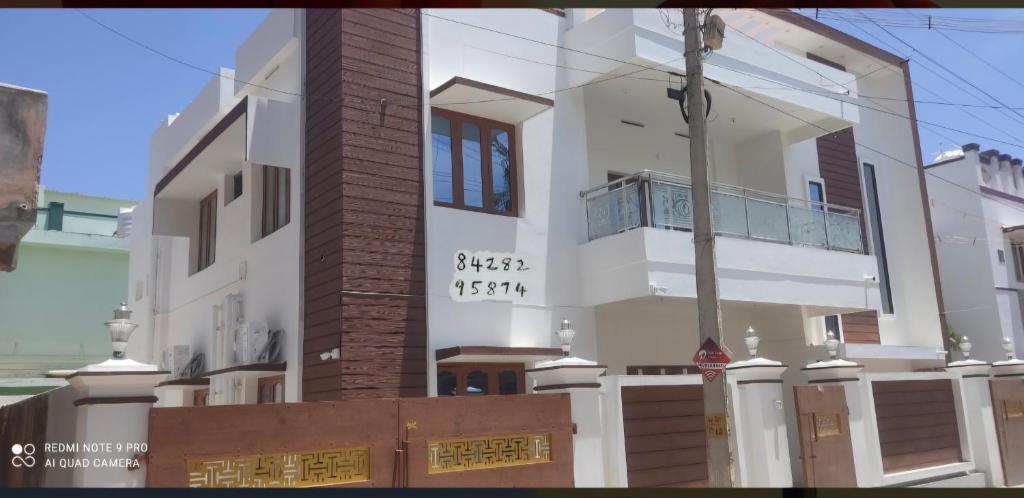 a large white building with a balcony on it at Velli apartment in Tirunelveli