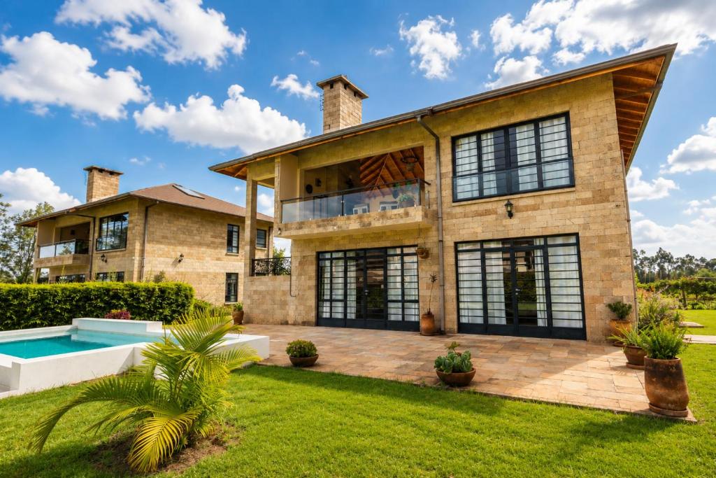 an exterior view of a house with a swimming pool at The Landing Cottages Family Suite 2 Bedroom in Nanyuki
