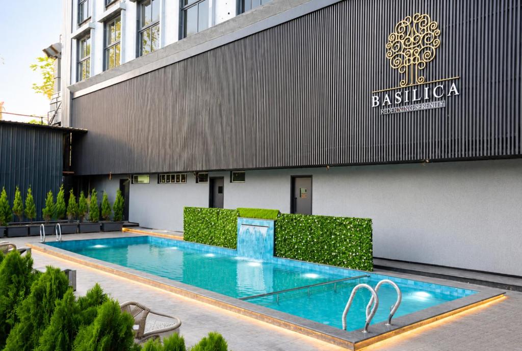 a swimming pool in front of a building at Basilica Resort, Lonavala in Lonavala